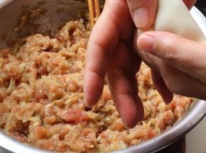双手拇指与食指压住饺子的边缘部位。