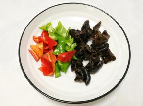 青红椒切滚刀块。木耳泡发洗净。