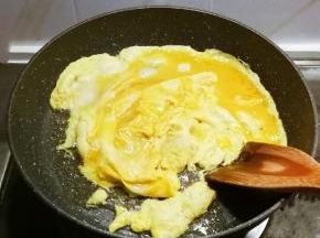 锅中放入一汤匙食用油 倒入鹅蛋液 翻炒成大块儿。