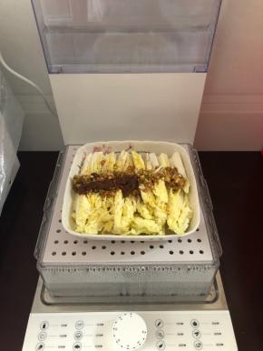 把盘子摆在蒸汽料理机上。