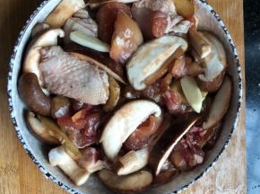 香菇洗净切片摆入盘子里，和鸡肉混合。