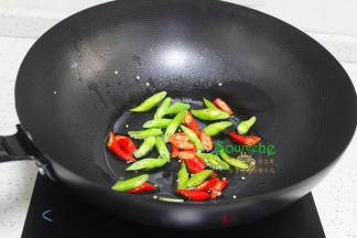热锅倒入少许油，倒入青辣椒、红辣椒炒至外皮皱皱的，接着放入韭菜，韭菜容易熟，所以要先炒好辣椒。