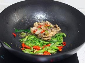 转为旺火，把解冻的小章鱼，倒入锅里爆炒，解冻的小章鱼有很多汤汁，要开始把固体和液体炒均，煮至入味。