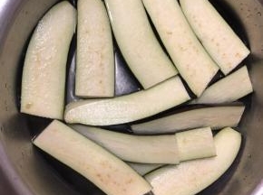 茄子切段后摆入盘里泡15分钟，加少许白醋。