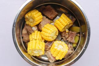 排骨连同姜片一起放入锅中，加上玉米。