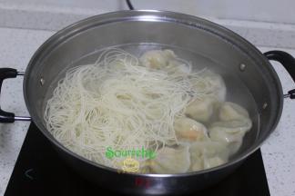 把煮好的面条放入饺子锅里，并搅拌均匀，让面条和饺子完美结合。再次把面条、饺子煮熟。
