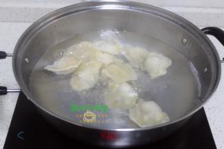 把煮锅清洗干净，倒入适量的水煮沸之后放入饺子，加少许盐，再次煮沸，然后加一碗冷水煮至饺子浮在水面上。