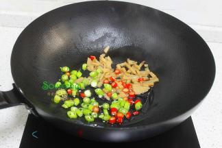 热锅，把酸笋倒入锅里煸炒几秒之后，倒入油，转为旺火，把红辣椒、青椒放入锅里爆炒八成熟。酸笋含水分多，要在无油锅里炒锅，才能放油，这样的味道才好吃。