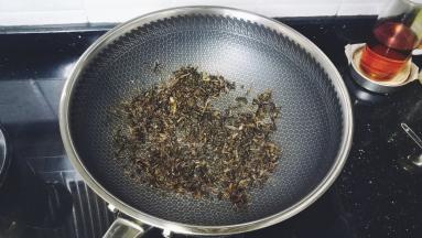 梅菜干用水浸泡冲洗干净，沥干水分后倒入锅里放少许糖炒干