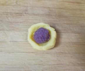 取一份绿豆泥捏成小碗状，放入豆沙馅。