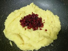 翻炒至细砂糖完全融化，绿豆泥能抱成团的时候，加入切碎的蔓越莓干。