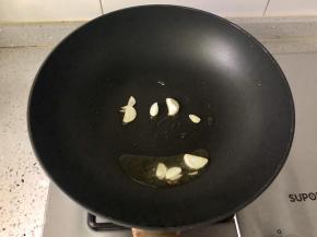 锅里放入食用油，中火，放入蒜片爆香。