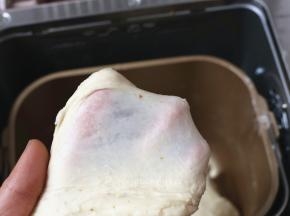 除黄油外，将面团中的其它原材料放入面包桶中，启动一个揉面程序，揉至能拉出厚膜。