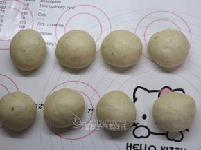 发酵好的面团按压排气，平均分成8个面团，滚圆之后盖上保鲜膜松弛15分钟。