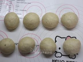 发酵好的面团按压排气，平均分成8个面团，滚圆之后盖上保鲜膜松弛15分钟。