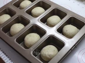 松弛好的面团压扁，再次滚圆后放入学厨金色8连杯不沾迷你磅蛋糕模中。