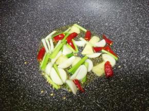 锅底留余油，下入葱白、蒜片、生姜片和干红辣椒炒香。