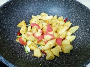 下入红萝卜和煎好的土豆翻炒均匀。