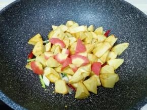 下入红萝卜和煎好的土豆翻炒均匀。