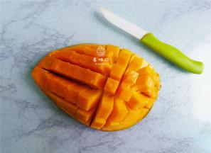 首先把芒果切半，划十字花刀把果肉剔除下来。