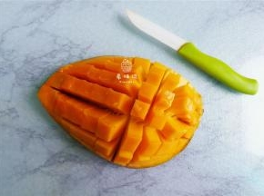 首先把芒果切半，划十字花刀把果肉剔除下来。