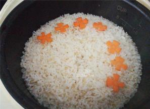 藜麦饭已经煮制好后，把切好的简易花放入蒸制断生，饭盛出扣入盘中，浇上鲍汁海参，胡萝卜花装饰下即可食用了。