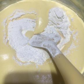 离开热水盆，过筛入蛋糕粉，翻拌均匀。