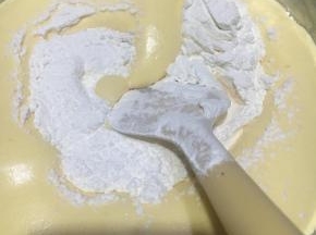 离开热水盆，过筛入蛋糕粉，翻拌均匀。