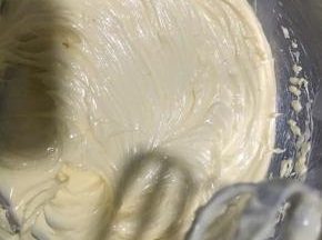 冷却后的蛋黄糊倒入软化好的黄油中打发呈现至羽毛状