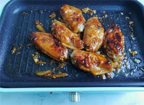 把碗中混合的酱料倒入锅中，让鸡翅裹上继续煎制会，小火防止糊锅。