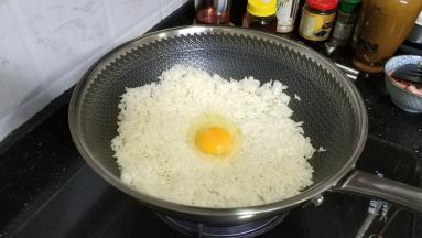 把饭平铺，打入鸡蛋一个