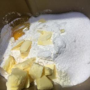 以上配方适用于学厨7寸金色迷你圆形活底不粘菊花边挞盘派盘模具一份用量
挞皮所需配料一同倒入面包机桶内，打启动和面程序10分钟，揉至松散一捏即可成团的状态。