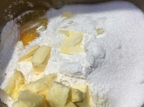 以上配方适用于学厨7寸金色迷你圆形活底不粘菊花边挞盘派盘模具一份用量
挞皮所需配料一同倒入面包机桶内，打启动和面程序10分钟，揉至松散一捏即可成团的状态。