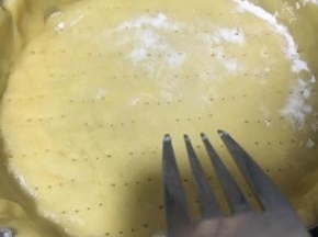 用叉子在挞皮表面戳上小洞，防止在烘烤时底部膨胀破裂，注意别戳透。