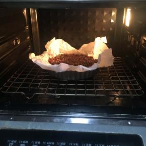 放入东菱烤箱上下火180烘烤15分钟后取掉油纸和红豆再次烘烤5分钟待凉备用。