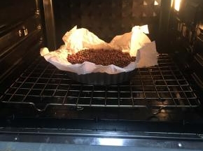 放入东菱烤箱上下火180烘烤15分钟后取掉油纸和红豆再次烘烤5分钟待凉备用。