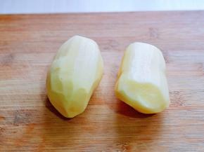 首先将土豆去皮，洗干净，放砧板上。