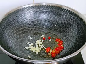 锅底留油，加入蒜末与辣椒段煸炒。