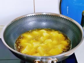 下入擦干水分的土豆块，用筷子来回翻动。