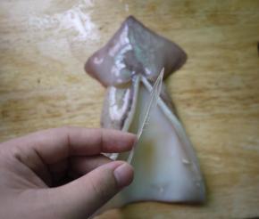 鱿鱼清洗干净后挤去眼睛、牙齿和鱿鱼须上白色的吸盘，剖腹，去除内脏和软骨。