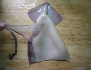 撕掉鱿鱼背部的黑膜，这层膜不撕掉会影响口感。