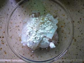 把处理好的鱿鱼放在小碗中，加一点淀粉，搅拌均匀。