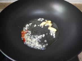 另起油锅，油加热后加入蒜泥、姜片和辣椒爆香。