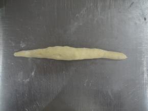 松弛后的面团，排气整形。将面团搓成长条，约25厘米，中间粗两头细。