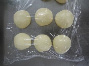 将面团拿出排气，分割成50G每个的小面团，滚圆后盖保鲜膜松弛15分钟。