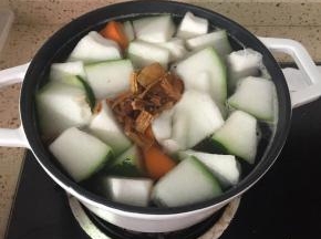 水开了之后加入冬瓜、红萝卜、党参、陈皮，继续大火煮至沸腾，转小火煲30分钟。