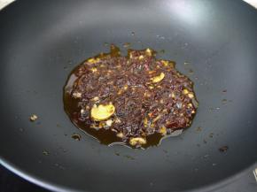 锅烧热，加入花生油，把大蒜、姜片放进锅里爆香，然后转小火，把豆瓣酱放入，煸炒出红油。放入豆瓣酱后要用小火，否则容易焦。