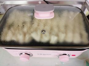 花卷胚发酵好了，在锅边淋一点点油，旋转到小火，全程用小火力煎，至底部煎至浅色了，再沿锅边有空隙的位置倒入小半碗的开水，盖上锅盖，继续煎。水不能倒太多，制作蒸汽是为了使花卷尽快煎熟