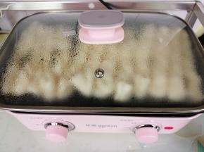 花卷胚发酵好了，在锅边淋一点点油，旋转到小火，全程用小火力煎，至底部煎至浅色了，再沿锅边有空隙的位置倒入小半碗的开水，盖上锅盖，继续煎。水不能倒太多，制作蒸汽是为了使花卷尽快煎熟