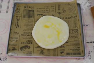 烤盘垫上油纸，放上香蕉芝士饼胚，表面刷上蛋黄液。